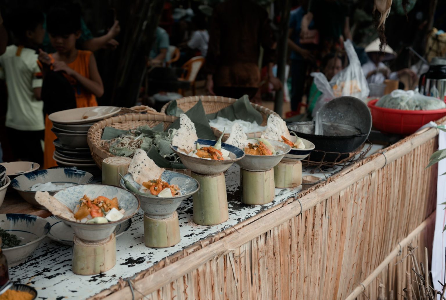 Mercado movimentado de comida de rua com barracas que exibem pratos da culinária asiática.