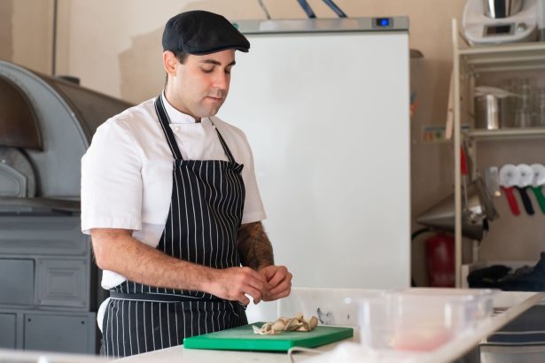 Chef prepara um prato em uma cozinha profissional.